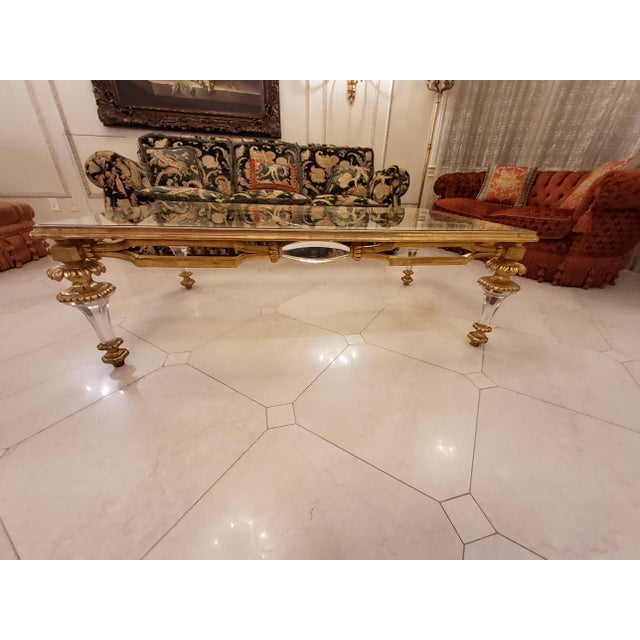 Golden glass coffee table. The frame is wood, with Lucite elements in the feet and the length of the base.