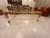 Golden glass coffee table. The frame is wood, with Lucite elements in the feet and the length of the base.