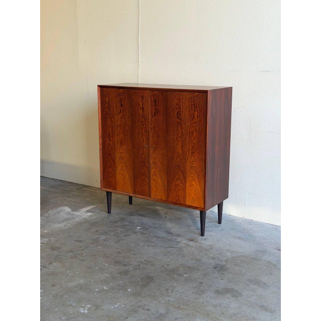 Danish cabinet crafted in richly grained rosewood, showcasing the clean lines and refined proportions that define classic...
