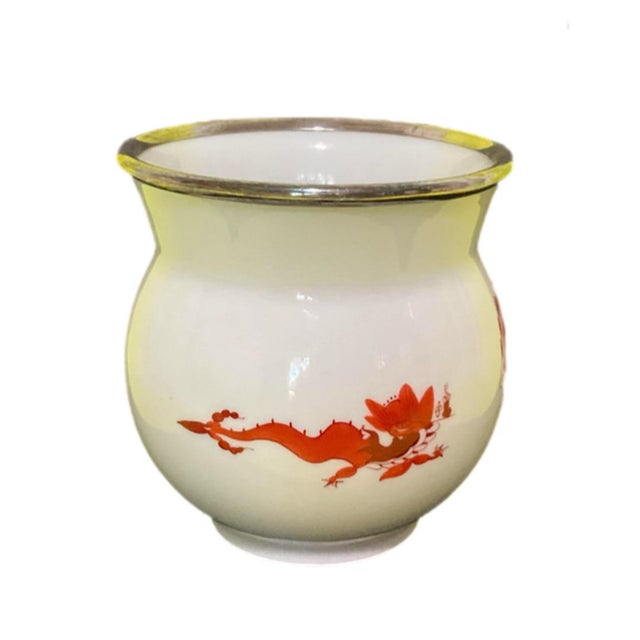 This round creamy white porcelain vase or jar features vibrant red painted designs of stylized birds, dragons and perhaps...