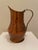 A sculptural vintage hammered copper pitcher featuring a warm, richly aged surface and cast brass handle. The vessel has a...