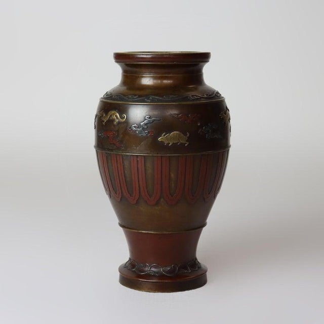 An antique Japanese vase from the Meiji Period, circa 1910, crafted from bronze with intricate mixed metal applications....