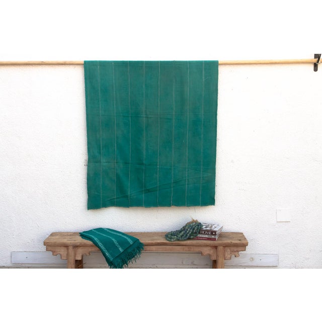 A rare regional variation of West African indigo, featuring saturated teal-green hues and hand-stitched details. This...