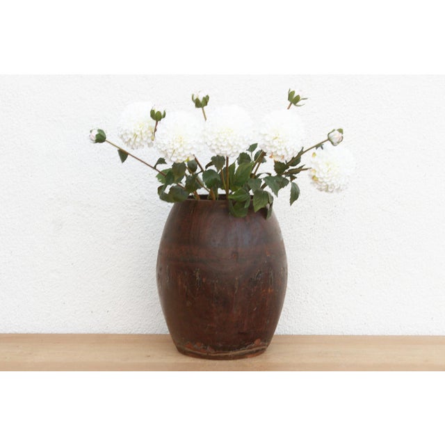 This large antique wooden pot is a relic of the old trade routes. Before digital scales, village merchants used solid...