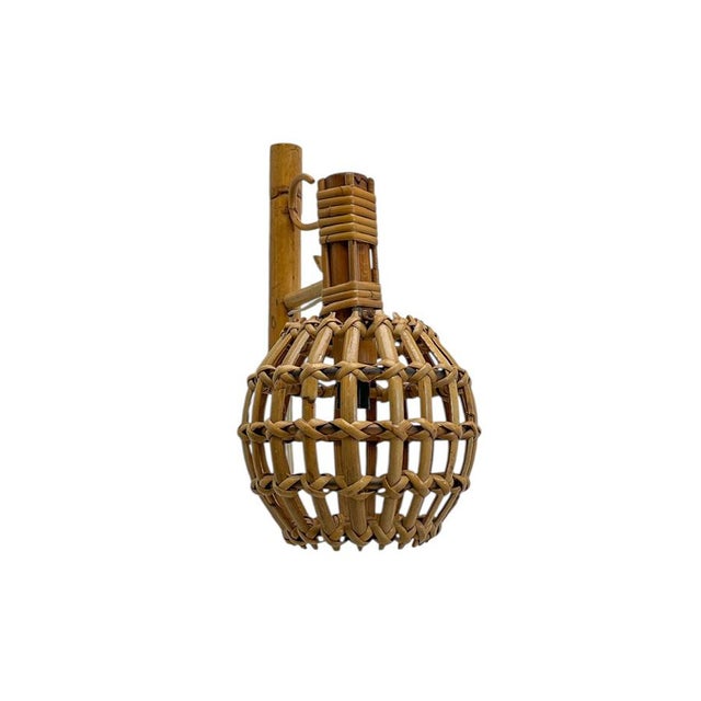 Fantastic lantern-style wall lamp in bamboo and rattan, attributed to Louis Sognot. Featuring a sculptural wall mount with...
