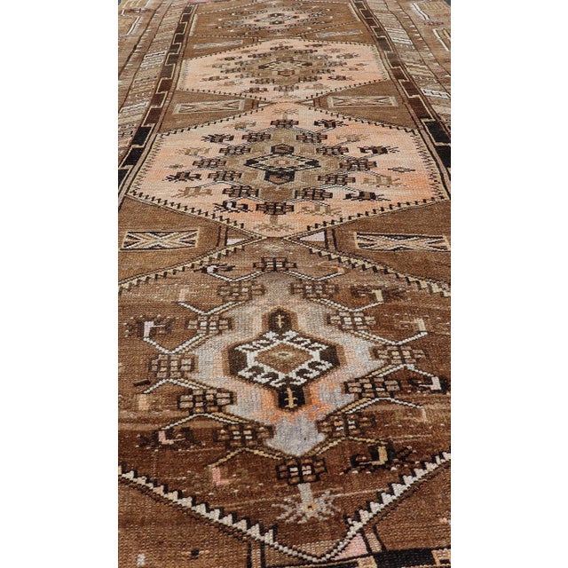 This vintage Turkish Kars gallery rug has been hand-knotted in wool and features a sub-geometric medallion design rendered...