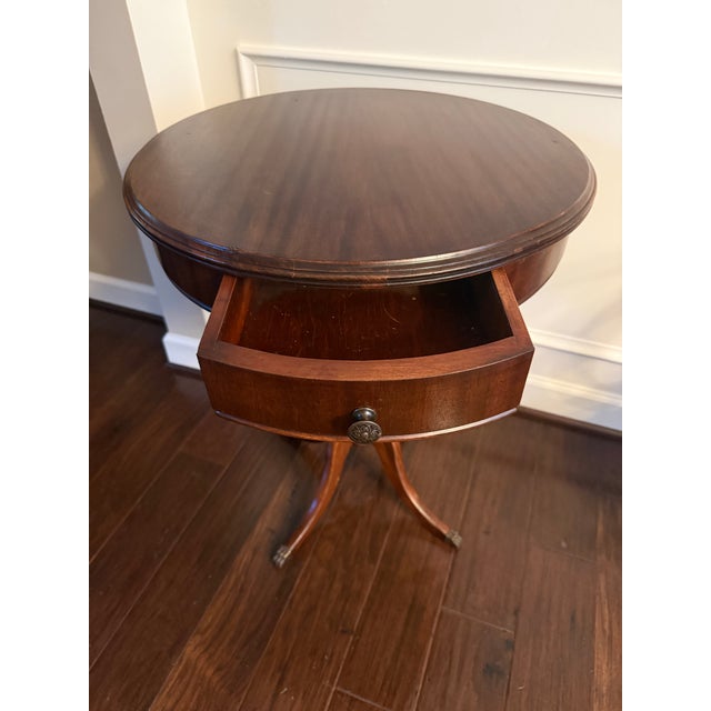 Add classic elegance to your entryway, living room, or study with this vintage Regency-style mahogany pedestal drum table....