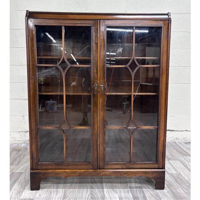This is a beautiful vintage Georgian Revival mahogany bookcase and display cabinet featuring double astragal-style glazed...