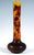 Tall vase with a disc-shaped base on a ring stand and a long, slender, straight neck; colourless glass with yellow-orange...