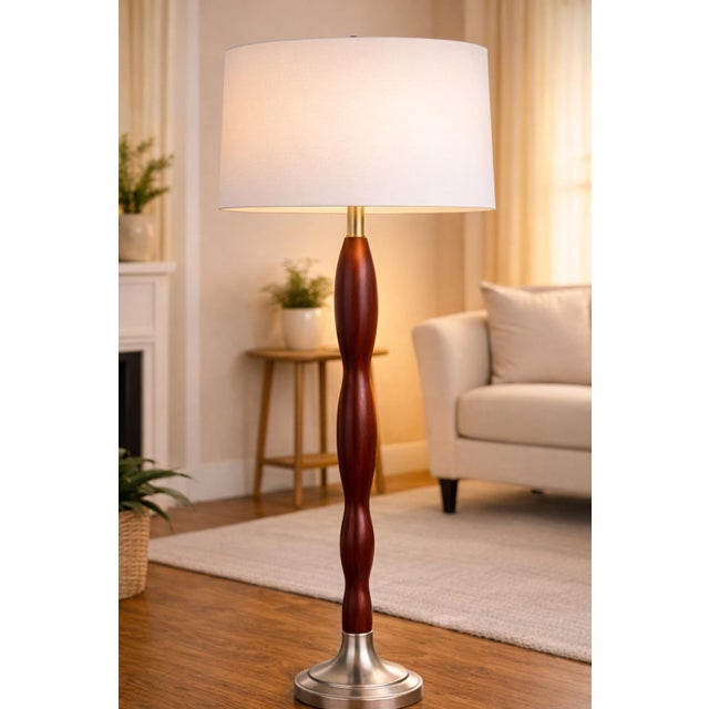 This striking pair of sculptural floor lamps embodies clean architectural form and timeless transitional design. Likely...