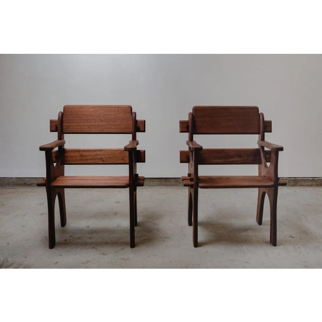 A pair of Brutalist solid wood armchairs. Crafted in rare Sipo/Utile mahogany. Belgium, circa 1960s. Sculpted arm chairs...