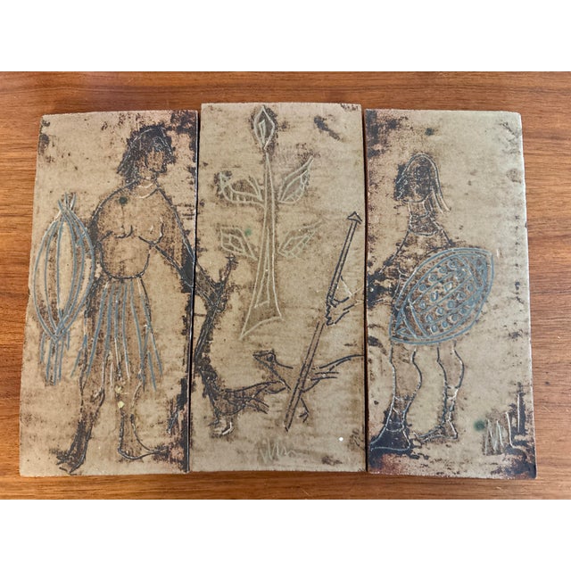 A compelling vintage triptych composed of three figural tile plaques, presenting a continuous narrative of stylized...