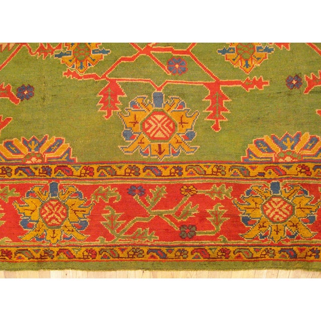 An early 20th Century Turkish Oushak Rug featuring a bright green field