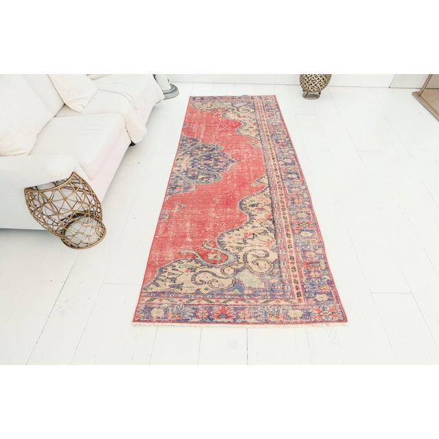 This is a vintage Turkish Oushak rug from the Mid 20th Century. The piece was hand-knotted.