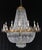 Empire style basket crystal chandelier with an ornate brass frame. This light requires twenty-four E-12 candelabra light...