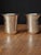 This listing features a matching pair of antique stemless silver Kiddush shot cups (beakers/tumblers) decorated with hand-...