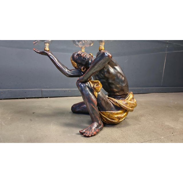 Remarkable coffee table consiting of two figurines in sculpted wood. Beautiful gold and bronze look finish. Good condition...