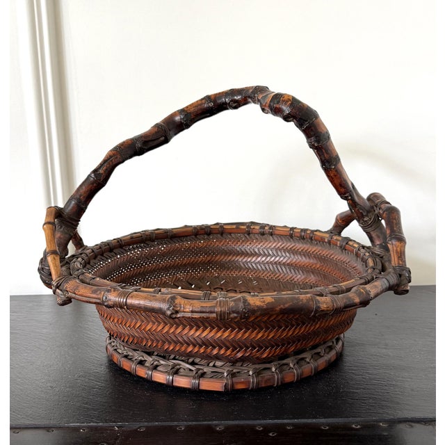 A Japanese woven bamboo basket with handle circa late 19th century of the end of Meiji period. The basket was constructed...