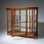 Large Biedermeier display cabinet in cherrywood with glazing on three sides and a mirrored back. The cabinet features a...
