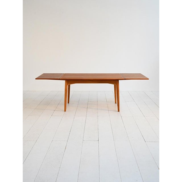 Table with teak top and oak legs, extendable on both sides. Danish production, 1960s. A Danish dining table from the...