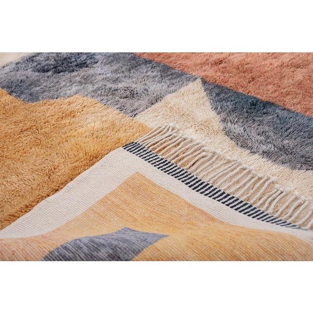 A composition of interlocking geometric shapes — navy blue, warm rust, dusty rose, and honeyed gold blocks arranged with...