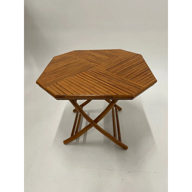 Schnazzy 8 sided bamboo table with folding legs having beautifully crafted top with triangular sections of bamboo laid out...