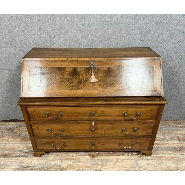 Louis XV period writing commode in walnut, burr walnut, and marquetry stringing, circa 1750 The front opens with three...