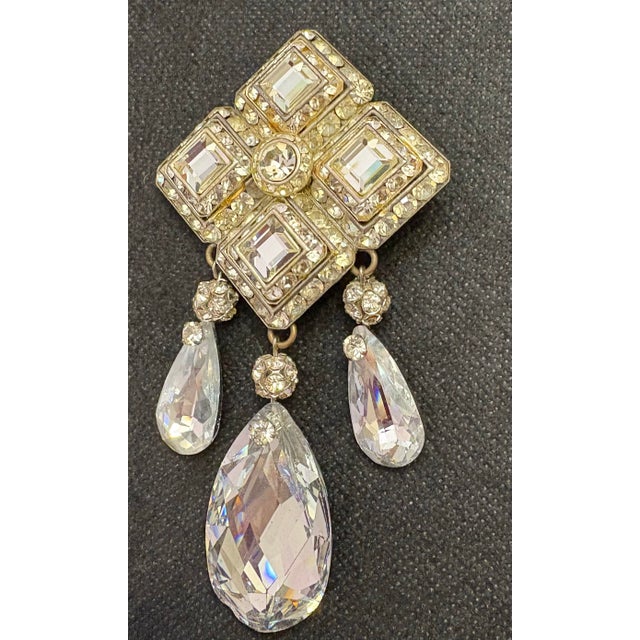 This is an Art Deco-style rhinestone statement brooch pin with a silver-tone finish. The design features a rhombus shape...