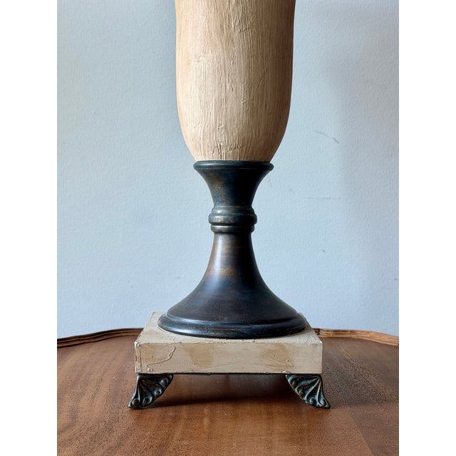 Vintage neoclassical table lamp featuring a textured faux stone finish, bronze-tone metal accents, square plinth base with...