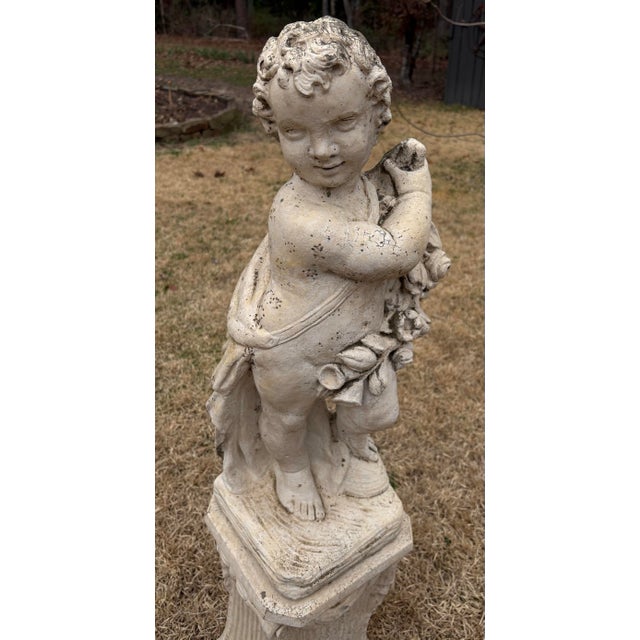 Awesome vintage cast concrete garden statue of a cherub or putti holding a floral garland with verdigris . Base is signed...