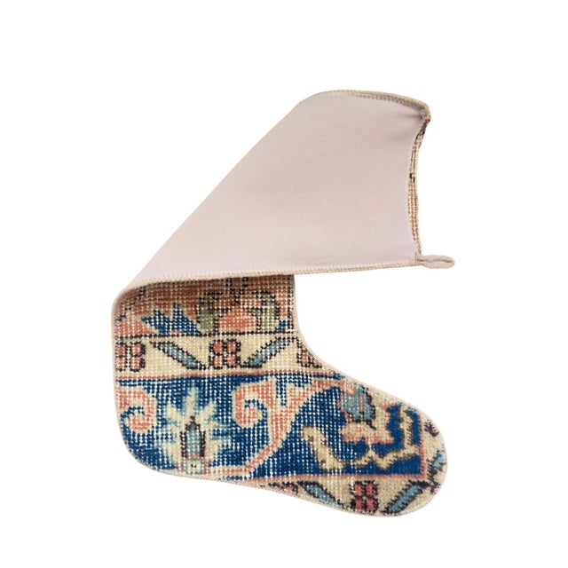 This vintage wool kilim stocking is a true showpiece — a vivid coral field centered on an intricate floral medallion,...