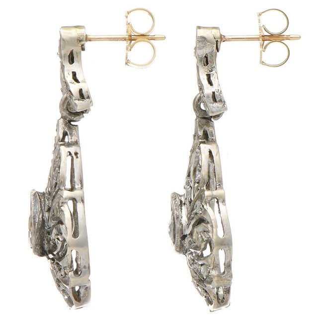 Silver is the material of choice for the classic appeal of these vintage drop earrings. Their pear-shaped, rough diamonds...