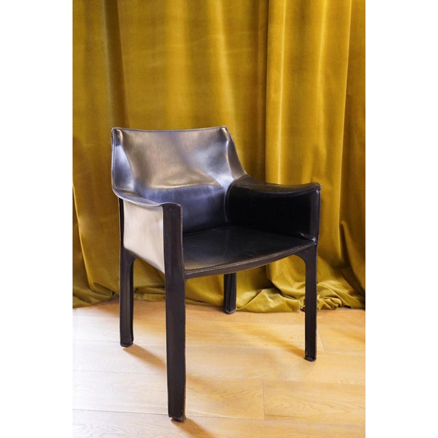 Cab 413 armchair in black leather by Mario Bellini for Cassina. The Cab armchair consists of a tubular frame over which a...