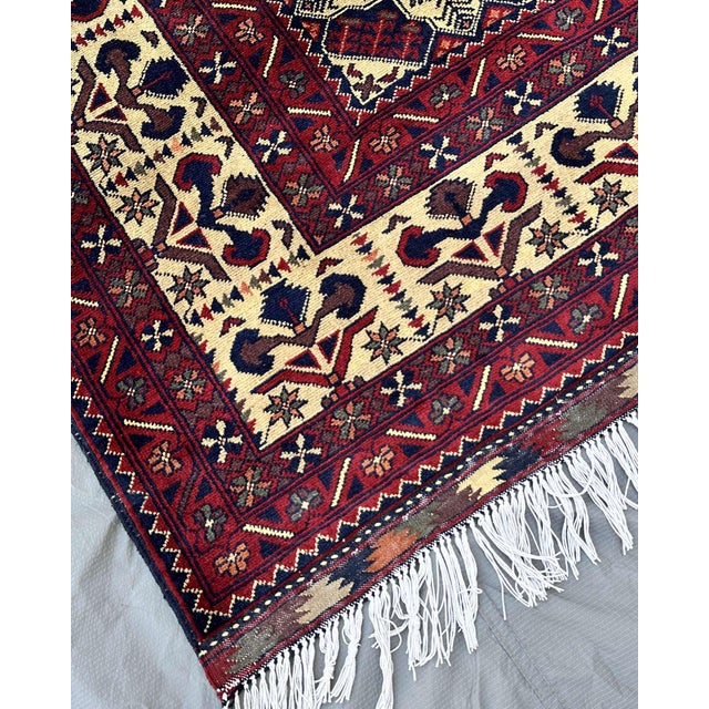 The ivory star lattice of this hand-knotted Afghan Turkmen rug reads like a constellation against a deep navy ground....