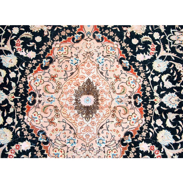 A fantastic late 20th century Persian silk and wool Tabriz rug with a large central floral medallion living amidst even...