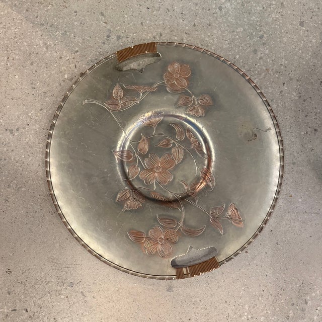 This large mid-century hand-wrought aluminum serving tray platter features etched dogwood floral motif in a warm copper...