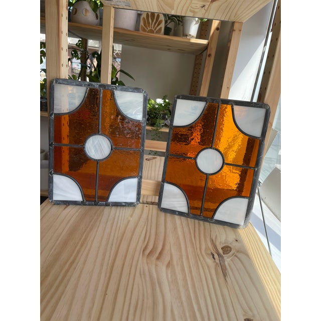 This pair of vintage stained glass panels features a bold geometric design crafted with rich amber-colored textured glass...