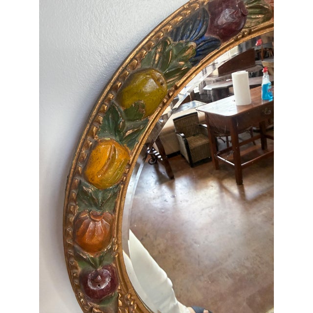 A fine round Barbola mirror from England featuring a relief of fruit - in polychrome colors applied over a gesso base -...