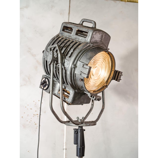 A 1950s arri 2kw fresnel film spotlight, reworked into an adjustable floor lamp on a rolling tripod stand. arri, founded...
