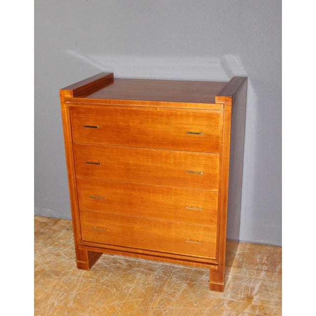 A designer chest of drawers circa 1970 in cherry wood, featuring four drawers, gilt bronze mounts, and a varnished finish;...