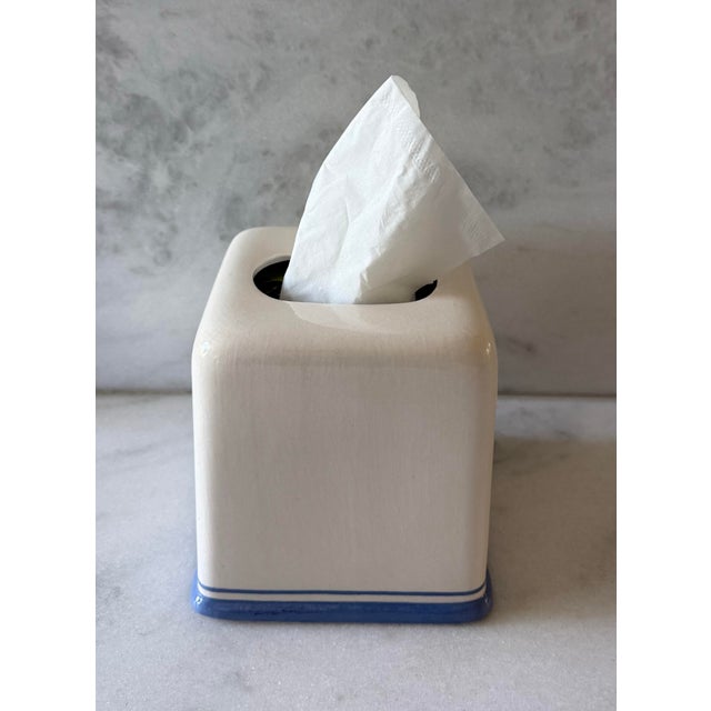Vintage ivory ceramic square tissue box cover featuring rounded corners and a blue and trim around the base.