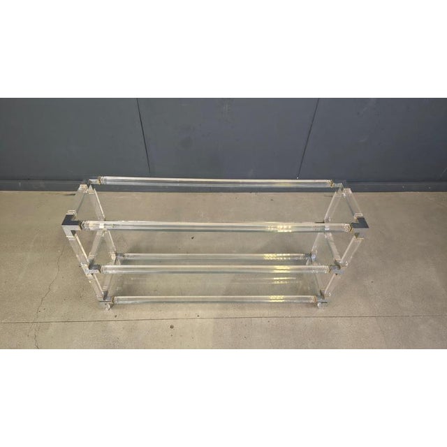 Three tiered console/etagere attributed to Charles Hollis Jones. Made of an acrylic frame with clear glass tops and...