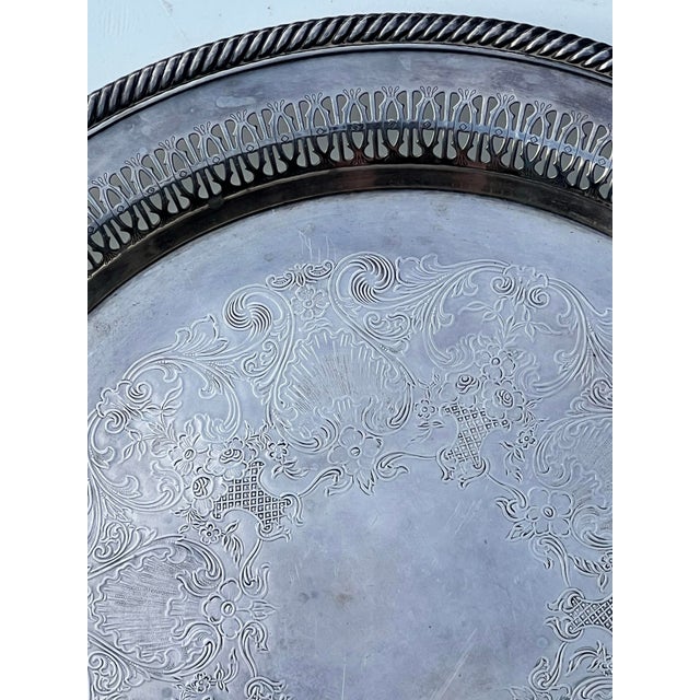 This elegant mid-century silver-plated round serving tray by Wm. Rogers exudes traditional sophistication and Hollywood...