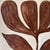 A strikingly graphic and sculptural original painting featuring an oversized tulip rendered in rich chocolate brown...