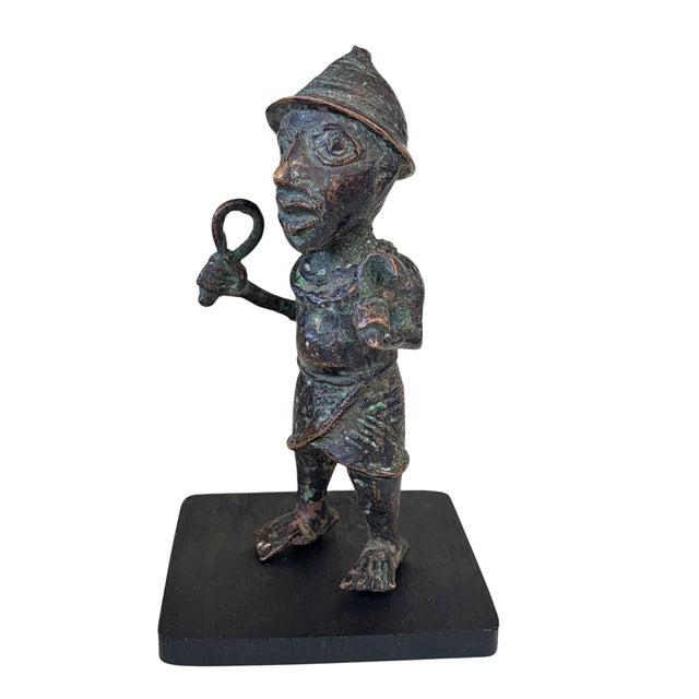 The Benin Bronze Oba King Soldier is a magnificent work of art from Nigeria, measuring approximately 6.25 inches in height...