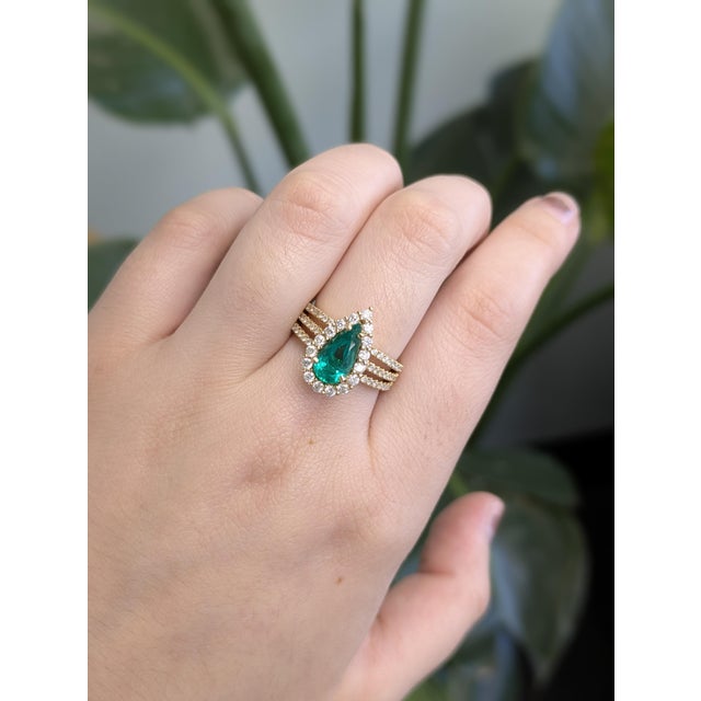 A standout statement with heirloom soul. Centered by a vivid GIA-certified 1.18 ct Colombian emerald, this ring is wrapped...