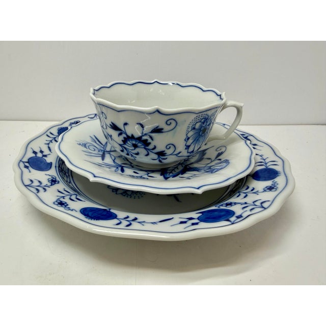 This authentic 3-piece porcelain place setting (trio) features the iconic Blue Onion (Zwiebelmuster) pattern, crafted by...