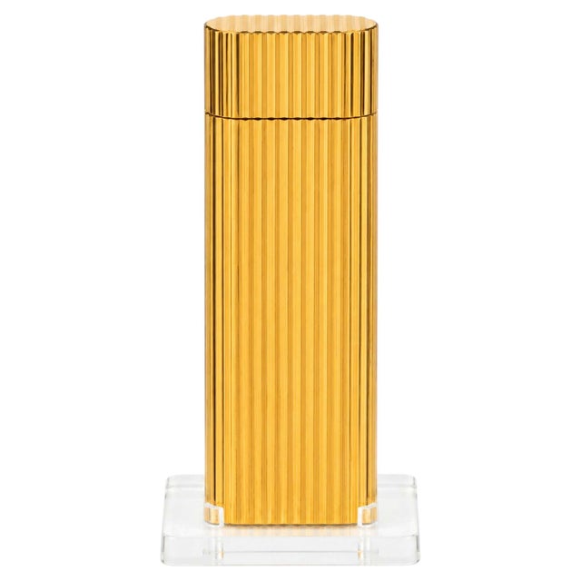 Vintage cartier godron pocket lighter with an oval body and parallel ribbed decoration in 18k gold plating. Offered with...