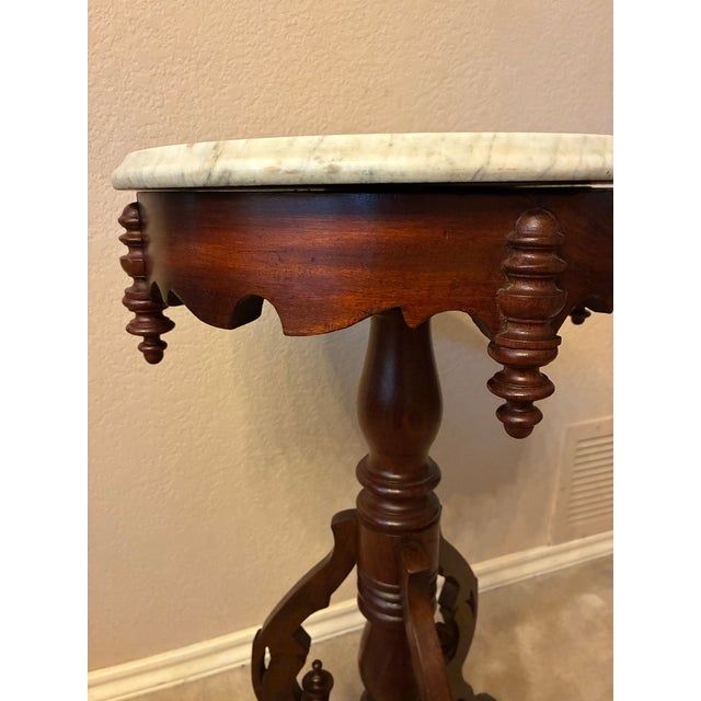 This walnut accent table with a beautiful Victorian style three legged base has a round white marble top which is...