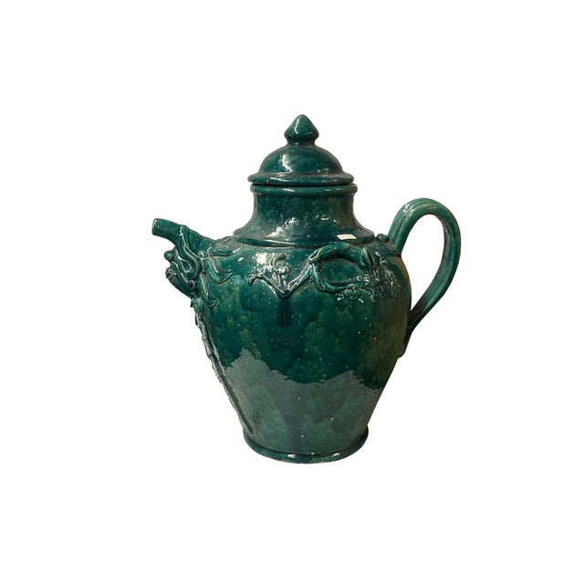 This antique-style Chinese ceramic wine jar features a rich, glossy teal-green lead glaze with natural pooled areas and...